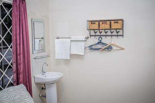 a white bathroom with a sink and a toilet at Sonja's Guesthouse in Zanderij