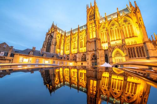 a large building with its reflection in the water at ☆ L'Exotique ☆ 2 chambres ☆ NETFLIX ☆ in Metz