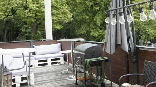 a grill on a deck with an umbrella at Fantazja Góra Św Anny in Góra Świętej Anny