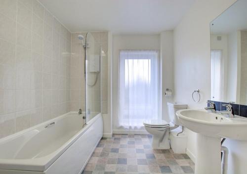 La salle de bains est pourvue d'une baignoire, de toilettes et d'un lavabo. dans l'établissement Sea Spirit - Sweeping Sea Views first floor spacious modern apartment in Looe- with FREE parking!, à Looe