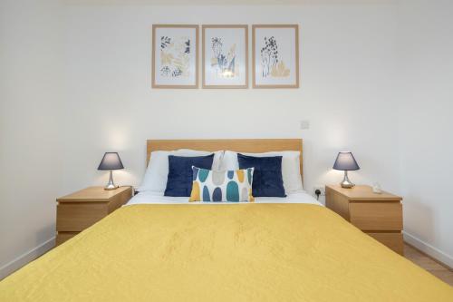a bedroom with a large yellow bed with two lamps at Cloud9SA at The Park Heights Woking in Woking