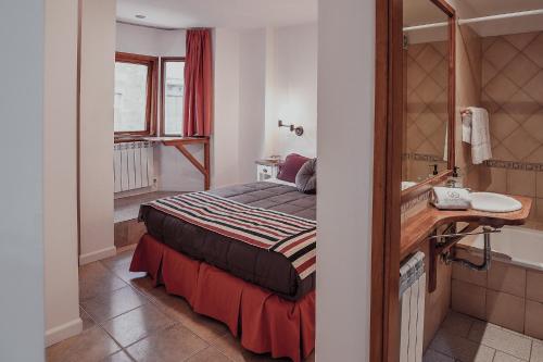 Habitación pequeña con cama y baño. en Isla Bonita Suites en Ushuaia