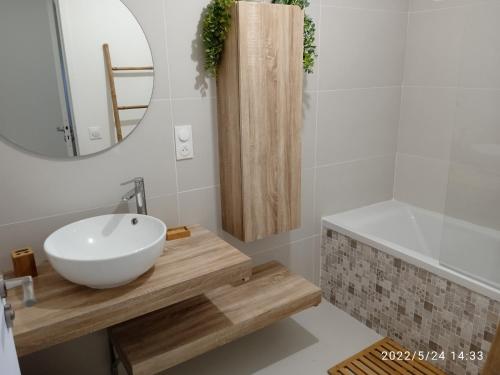 a bathroom with a sink and a mirror and a tub at Appartement en centre - résidence privée, vue mer in Porto-Vecchio