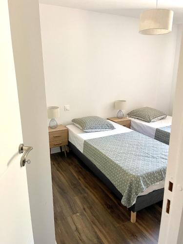 - 2 lits dans une petite chambre avec 2 lampes dans l'établissement Appartement en centre - résidence privée, vue mer, à Porto-Vecchio