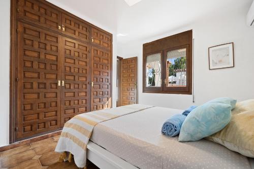 1 dormitorio con 1 cama y puerta de madera en Charming Mediterranean house with private jacuzzi sea and mountain views en Miami Platja
