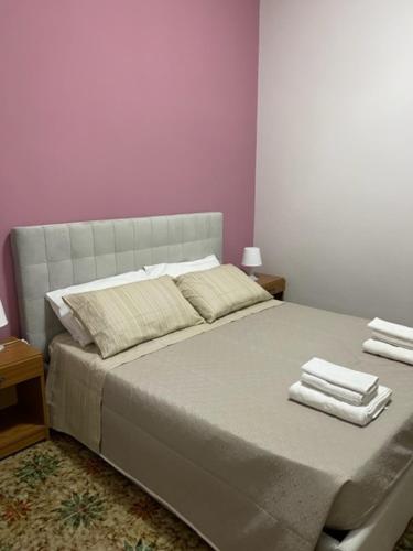 una camera da letto con un grande letto con asciugamani di Dimora Nonna Ada ad Aradeo
