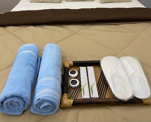 een dienblad met handdoeken en een camera op een bed bij SunsetHomes A luxurious studio apartment in Imphal