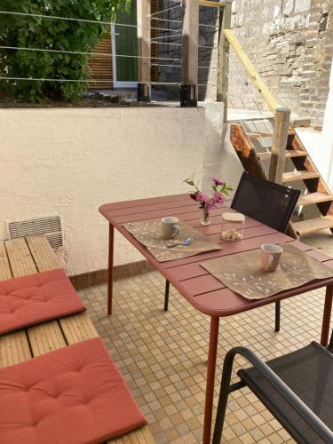 a table with two cups and a laptop on a patio at Le Flocmagny in Chalons en Champagne