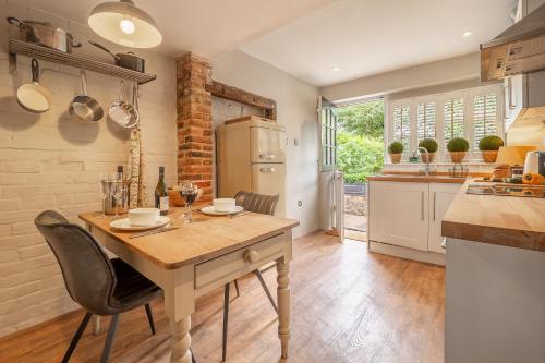 een keuken met een tafel en stoelen bij Utterly divine romantic retreat in brilliant village - Tudor Cottage in Sudbury