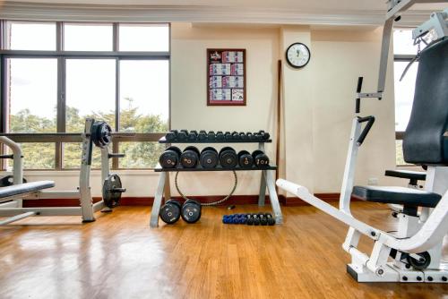 a gym with exercise equipment and a clock at Kibo Palace Hotel Arusha in Arusha