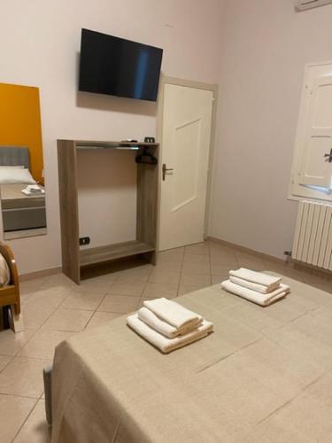 una habitación con una mesa con tres toallas. en Dimora Nonna Ada, en Aradeo