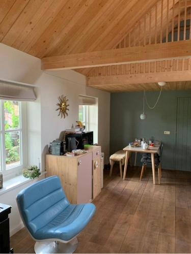 a kitchen with a blue chair and a table at B&B 't Varkenshuus in Aalten