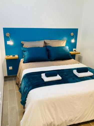 une chambre avec un grand lit avec deux serviettes dessus dans l'établissement Le Flocmagny, à Châlons-en-Champagne