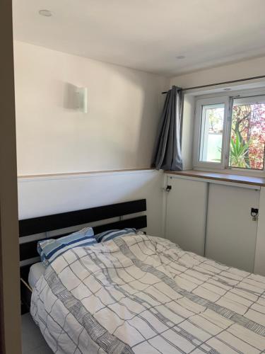 1 dormitorio con cama y ventana en Appartement en résidence climatisé avec parking, en Montpellier
