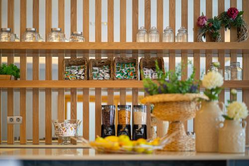 a shelf filled with jars and a table with flowers at Hotel Rural Vale Do Rio in Oliveira de Azemeis