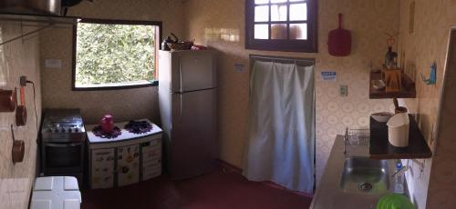małą kuchnię z lodówką i oknem w obiekcie Nuh Hostel w mieście Ouro Preto