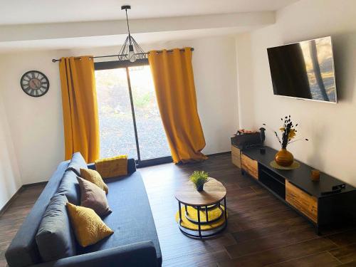 salon z kanapą i telewizorem w obiekcie Gîte Bella-K, logement privatif en campagne à Gesves w mieście Gesves