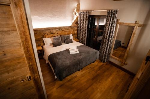 Chalet Hotel Dragon في بيريول تشيرفينيا: غرفة نوم صغيرة مع سرير ومرآة