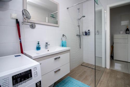 a white bathroom with a sink and a shower at Luxury Apartment Luna in Vantačići