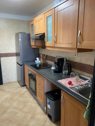 a kitchen with wooden cabinets and a black counter top at Chez balqis atlas golf in Marrakech