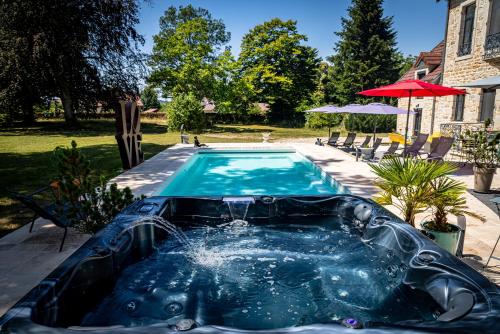 una piscina con bañera de elefante en un patio en Le 49 Côté Parc & SPA, en Domblans