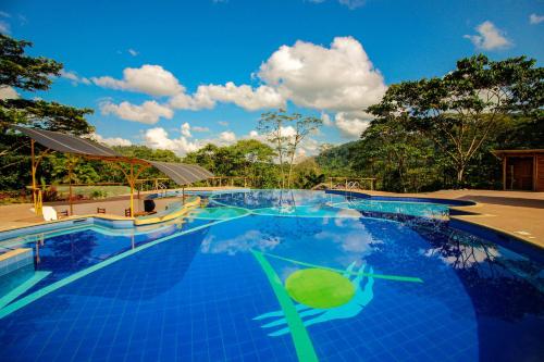 a large swimming pool with a blue at Hosteria Orkidea Lodge in Puyo