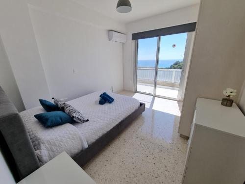 a bedroom with a bed with blue pillows on it at Diamond Sea View Penthouse in Paphos City