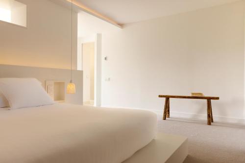 a white bedroom with a bed and a table at Ô PLUM'ART Chambres de caractère in Giverny