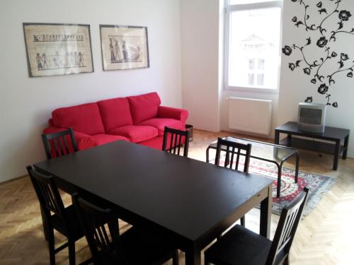 a living room with a red couch and a table at Anna 2 bedrooms 2 bathrooms 6 bikes in Budapest