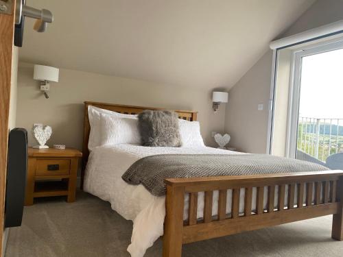 a bedroom with a bed and a large window at Moll’n’Cliff in Silsden