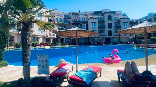 a swimming pool with chairs and umbrellas and a swimming pool at Свети Йоан in Sozopol