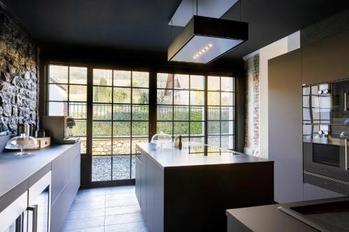 a kitchen with a large window and a kitchen island at Ô PLUM'ART Chambres de caractère in Giverny