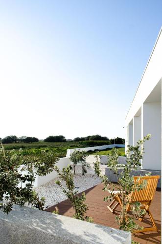 a deck with a chair and a body of water at Marinhas Bed & Breakfast in Esposende