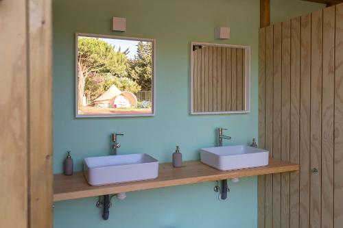 a bathroom with two sinks and a mirror at Glamping La Mimosa CONIL in Conil de la Frontera