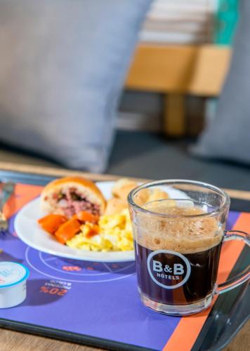 a tray with a plate of food and a cup of coffee at B&B HOTEL Rio de Janeiro Norte in Rio de Janeiro