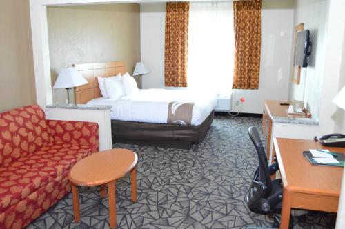 une chambre d'hôtel avec un lit et un canapé dans l'établissement Quality Inn Coralville - Iowa River Landing, à Coralville