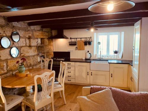 a kitchen with a table and chairs in a room at Cosy 400 yr old Cottage, Flowergate, Whitby in Whitby