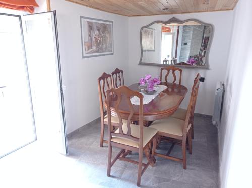 ein Esszimmer mit einem Tisch, Stühlen und einem Spiegel in der Unterkunft Casa Rural Estajero in Muñana