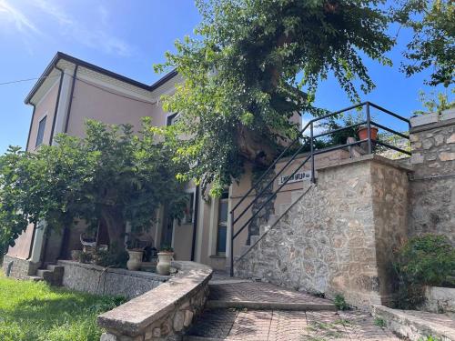 una casa con una pared de piedra y una escalera en L'Antico Gelso, en Viggiano