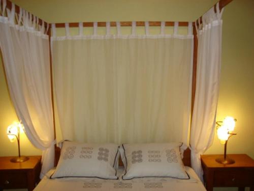 een bed met twee witte kussens en twee lampen bij Casa do Planalto Mirandês in Miranda do Douro