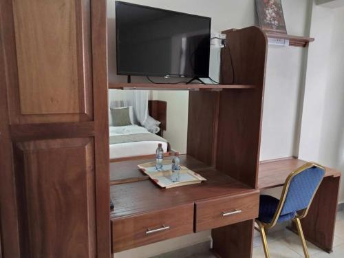 a wooden cabinet with a tv on top of it at Logmma Regency Hotel in Kakamega