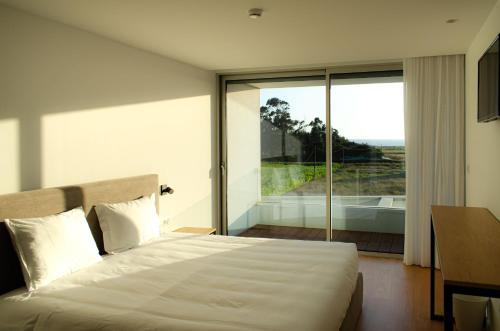 a bedroom with a large bed and a large window at Marinhas Bed & Breakfast in Esposende