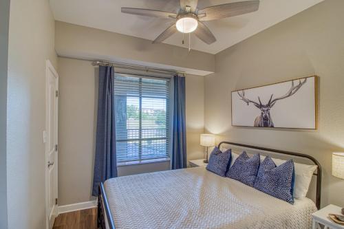 a bedroom with a bed with a ceiling fan and a window at Fantastic Location! River and Mountain Views 2BR/2BA Sleeps 6 in Pigeon Forge