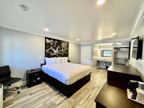 a bedroom with a bed and a desk and a chair at Aura Inn Monterey in Monterey
