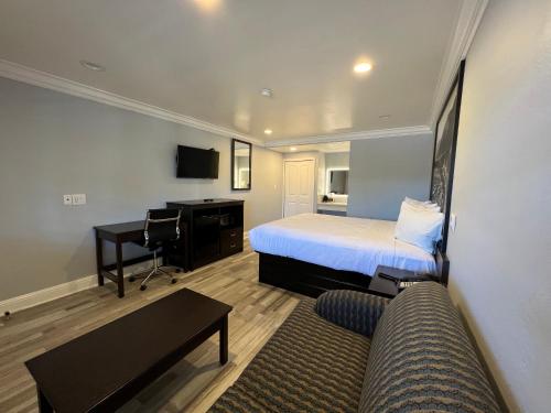 a hotel room with a bed and a desk at Aura Inn Monterey in Monterey