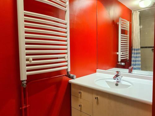 La salle de bains rouge est pourvue d'un lavabo et d'un miroir. dans l'établissement Spacieux Appartement 3 Pièces + Cabine à Flaine Forêt, Balcon & Parking - FR-1-425-134, à Flaine