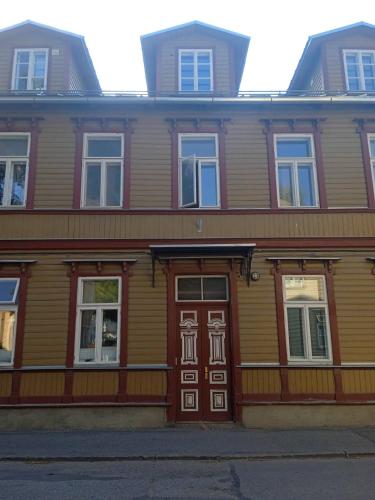a large wooden building with a wooden door at Hygge Home - artistic style apartment with free parking Friday 7 pm - Monday 8 am in Tartu