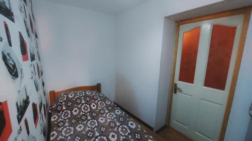 a small bedroom with a bed and a door at Buddha apartment in Tbilisi City