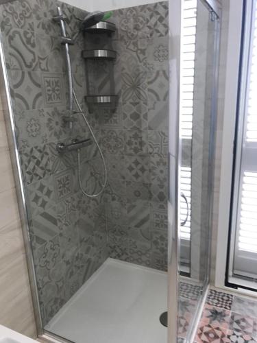 a shower with a glass door in a bathroom at Pipa House in San Donato di Lecce