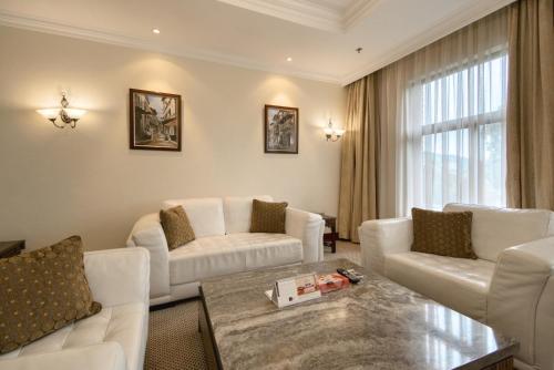 a living room with white furniture and a table at Kibo Palace Hotel Arusha in Arusha